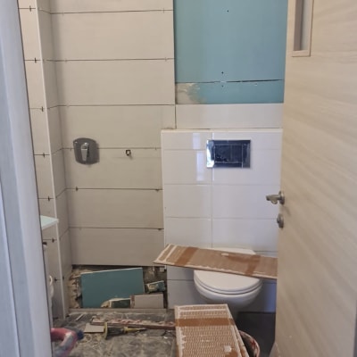 חדר אמבטיה בשיפוץ עם אריחים וכלים על הרצפה