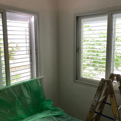 סולם עץ ויריעות פלסטיק ירוקות בחדר צבוע