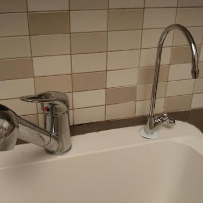ברזים מעל כיור מטבח עם אריחים ברקע