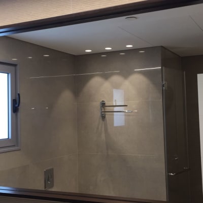 מראה גדולה עם מסגרת כהה בחדר אמבטיה