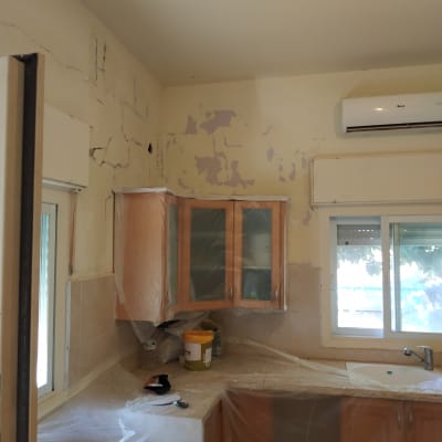 מטבח מכוסה בניילון לקראת צביעה, קירות מתקלפים