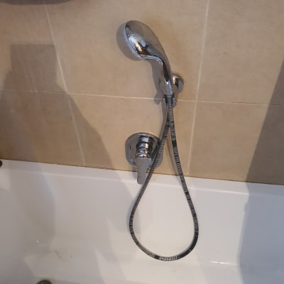 ברז מקלחת עם צינור מתכת וכפתור שליטה