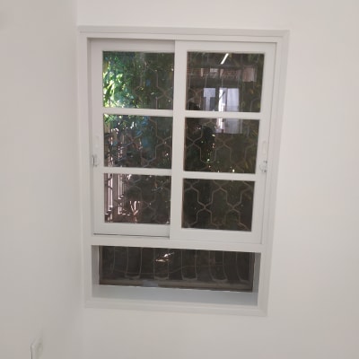 קיר צבוע בלבן עם חלון מסורג