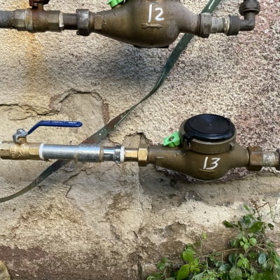 צינורות מים עם ברזים ומדי מים על קיר