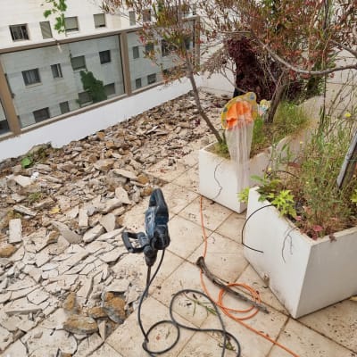 מקדחה חשמלית על רצפה מרוצפת עם כבלים