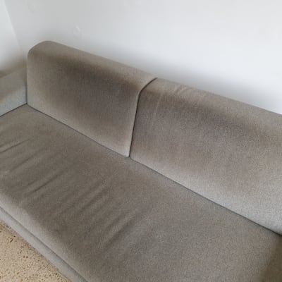 ספה אפורה עם כתמים על המושב והמשענת