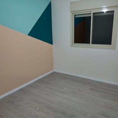 רצפת פרקט עץ בהירה בחדר ריק עם קיר צבעוני