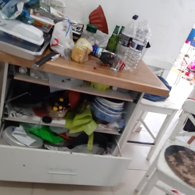 שולחן עמוס בבקבוקים, כלים חד פעמיים ואריזות פלסטיק