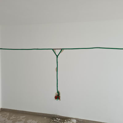 חוטי חשמל ירוקים מותקנים בקיר לבן