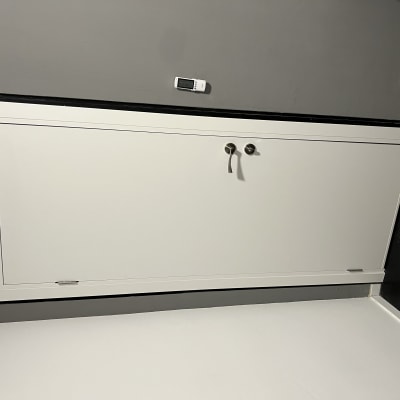 דלת לבנה עם ידיות מתכת על קיר אפור