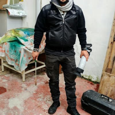 אדם מחזיק כלי עבודה בצורת צינור בחצר