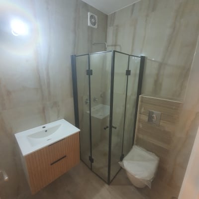 חדר אמבטיה משופץ עם מקלחון וכיור חדש