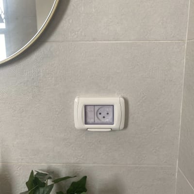 שקע חשמלי עם כיסוי שקוף על קיר אפור