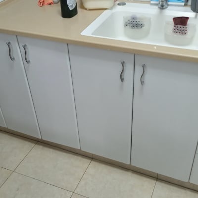 ארונות מטבח עם ידיות מתכת וכיור לבן