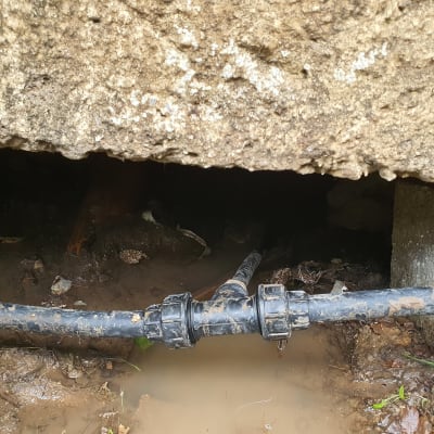 צינור מים עם חיבור מתחת לאדמה רטובה