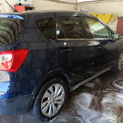 רכב כחול נשטף במים וסבון במוסך