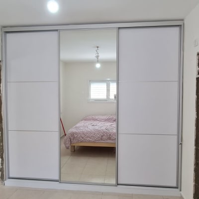 ארון הזזה עם דלתות לבנות ומראה