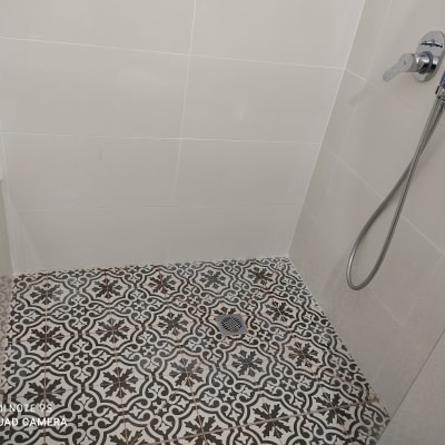 הוצאת אמבטיה, מקלחון לאורך הקיר כולל מדף ישיבה וריצוף.