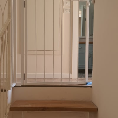 מעקה מתכת לבן על מדרגות עץ