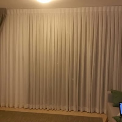 וילון לבן גדול עם קפלים בסלון מואר