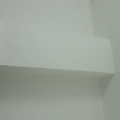 קיר לבן עם סימני צבע כהים בפינה