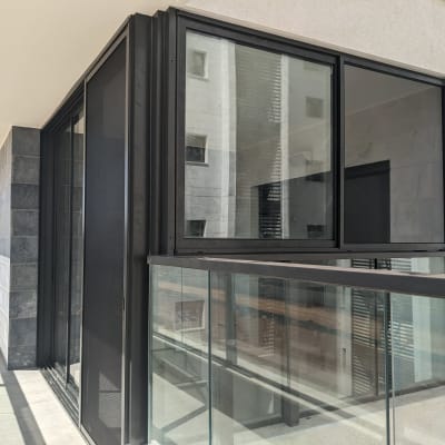 חלונות אלומיניום במרפסת עם מסגרת שחורה