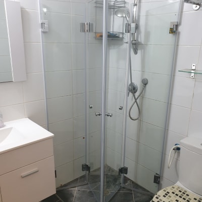 מקלחון זכוכית עם ראש מקלחת ומדף קטן