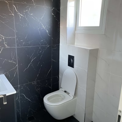 אסלה תלויה עם קיר שחור ולבן בחדר אמבטיה