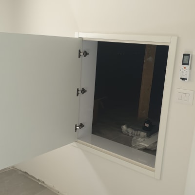 דלת ארון פתוחה עם צירים על קיר לבן