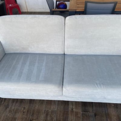 ספה אפורה נקייה על רצפת עץ כהה