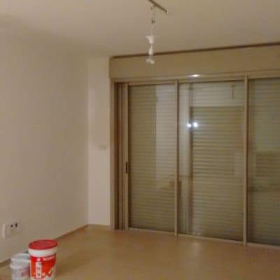 דלי צבע אדום ולבן על רצפה בחדר ריק