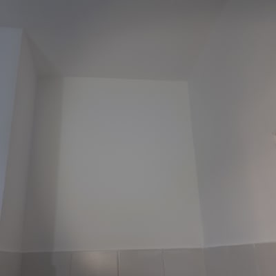 קיר צבוע בלבן עם אריחים אפורים בתחתית