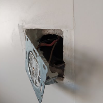 שקע חשמלי פתוח עם חוטים חשופים בקיר