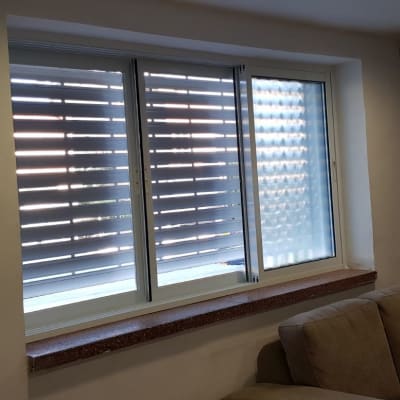 חלון עם תריסי אלומיניום סגורים למחצה