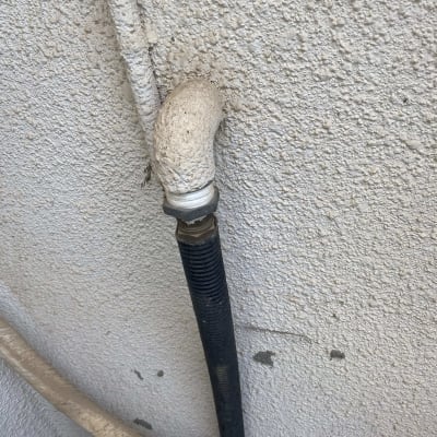 צינור מתכת מחובר לקיר עם חיבור זוויתי