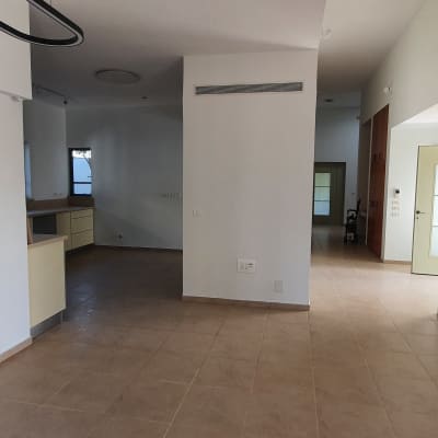 חדר ריק עם רצפת אריחים נקייה ודלתות זכוכית