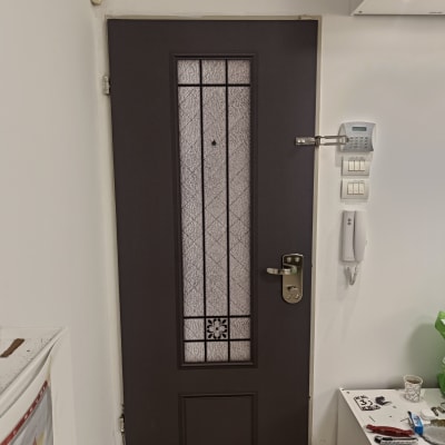 דלת חומה עם חלון זכוכית מעוצב ומנעול כסוף