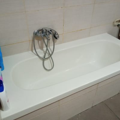 אמבטיה עם ברז ומוצרי טיפוח על הקצה