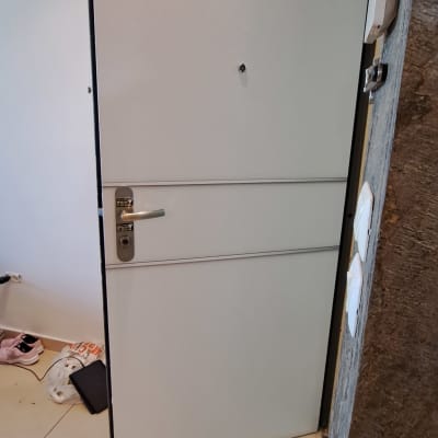 דלת מתכת אפורה עם ידית ומנעול