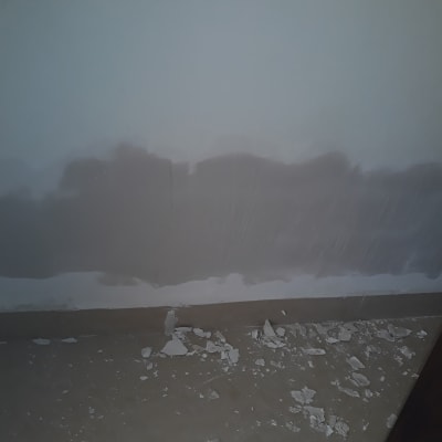 קיר צבוע חלקית עם שאריות צבע על הרצפה