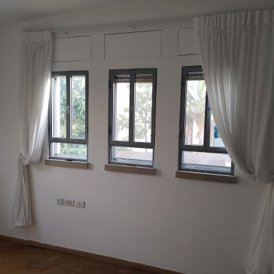 חדר עם קירות לבנים ווילונות לבנים