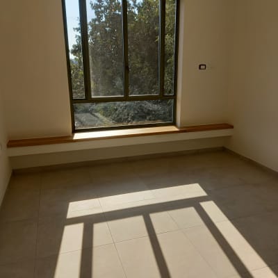 חדר ריק עם חלון גדול ורצפה נקייה