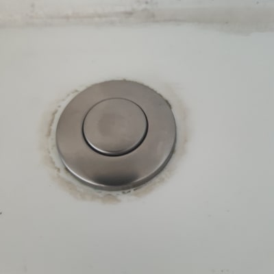 לחצן מתכת עגול על משטח לבן