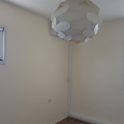 חדר עם קירות צבועים בלבן ומנורה מעוצבת