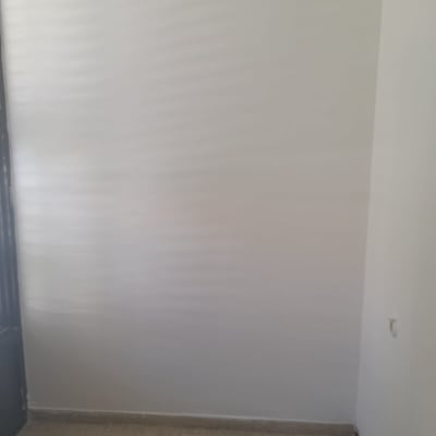 קיר צבוע בלבן עם רצפת אריחים