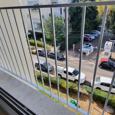 מעקה מתכת במרפסת עם נוף לרחוב