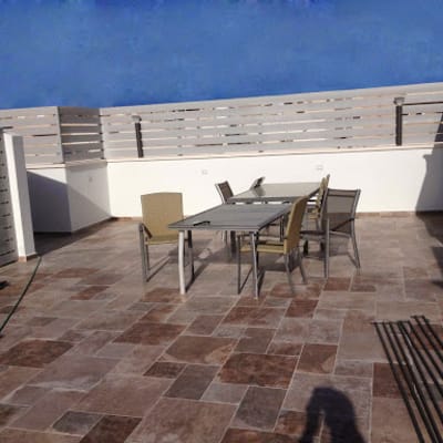 מרפסת עם שולחן וכיסאות על רצפת אריחים