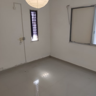 חדר ריק עם רצפה נקייה ומנורה תלויה