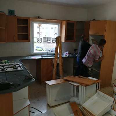 שני אנשים מתקינים ארונות מטבח חדשים