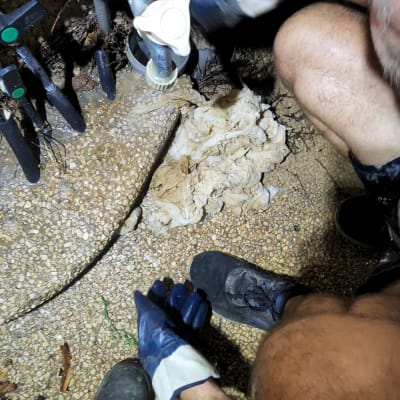 אדם עם כפפות עובד על צינור מים עם ברז